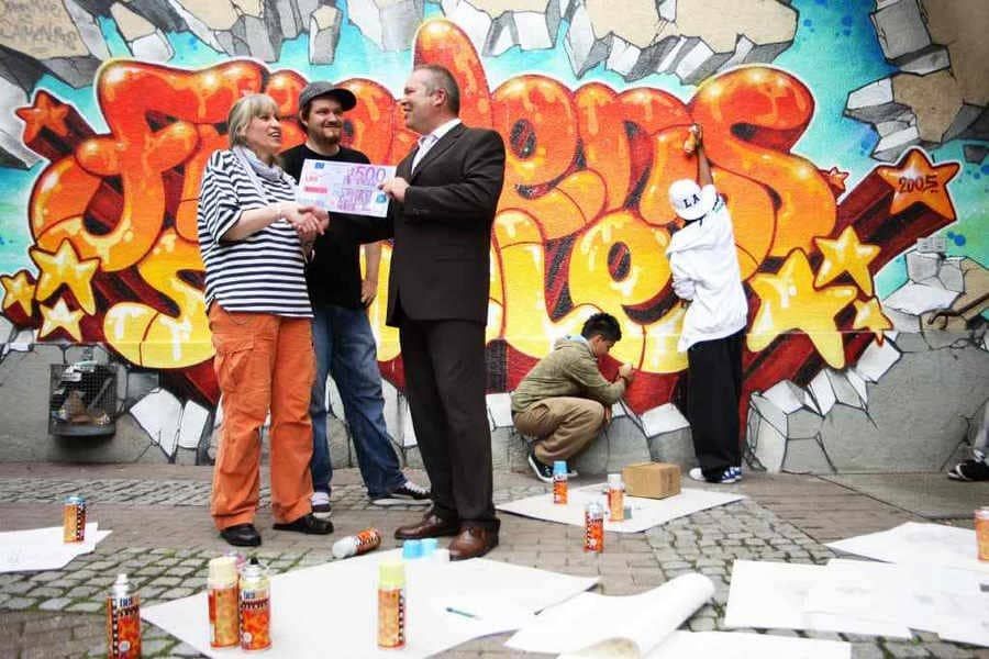 Graffiti-Projektabschluss mit Teamfoto – Ausdruck von Community & Reichweite.